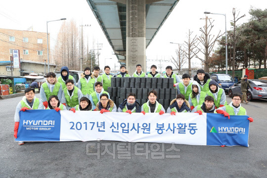 현대엔지니어링 신입사원들이 영등포 쪽방촌 주민에 연탄을 배달한 후 기념촬영하고 있다.<현대엔지니어링 제공>